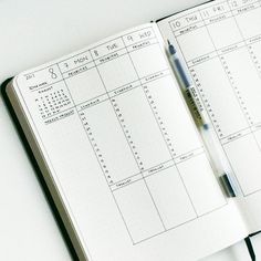 an open notebook with a pen on top of it and calendars in the pages