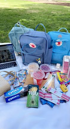 the picnic table is full of snacks, drinks and other things to pack up on