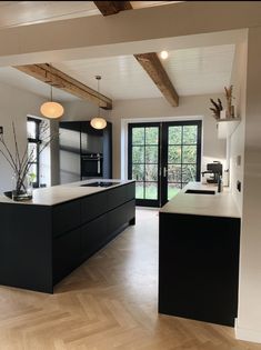 an empty kitchen with black cabinets and white counter tops