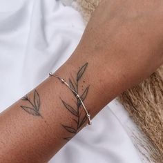 a woman's arm with a tattoo on it and a cross in the middle