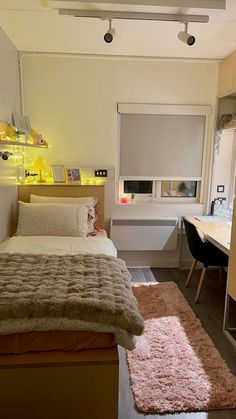 a bed room with a neatly made bed next to a desk and window sill