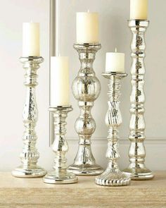 silver candles are lined up on a table