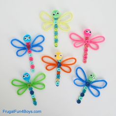 four dragonflys made out of plastic beads with eyes and hands on each side