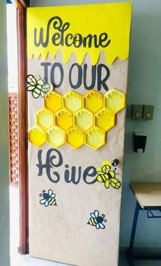 a welcome to our hive sign with bees and honeycombs painted on the front