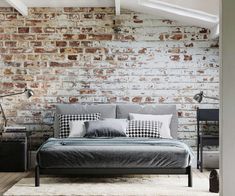 a bed sitting in front of a brick wall