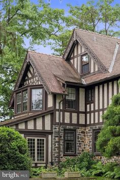 a large brown and white house surrounded by trees