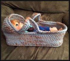 a crocheted basket with a doll in it