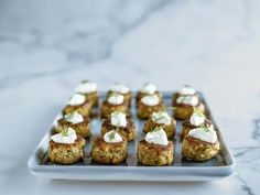 small appetizers are arranged on a plate with sour cream and mint garnishes