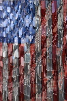 an american flag made up of many different colored glass beads and chains hanging from the ceiling