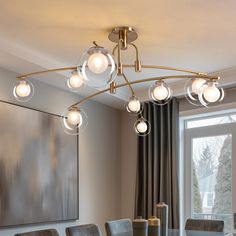 a dining room table with chairs and a chandelier hanging from it's ceiling