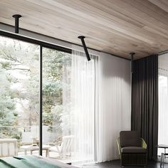 a bedroom with a bed, chair and sliding glass doors that look out onto the outdoors