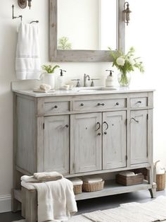 a bathroom with a sink, mirror and towels on the rack in front of it