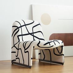 a black and white chair sitting on top of a hard wood floor