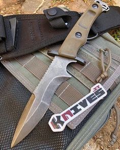 a knife sitting on top of a piece of luggage next to a pair of gloves