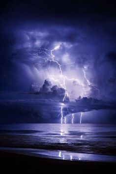 lightning strikes over the ocean on a cloudy day