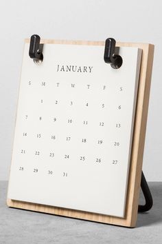 a calendar on a wooden stand with black handles