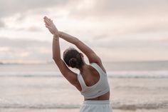 a woman stretching her arms on the beach