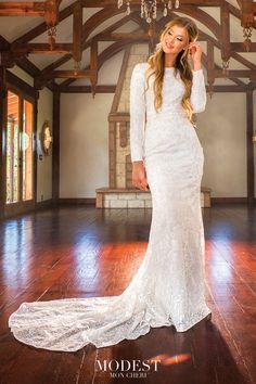 a woman in a white wedding dress posing for the camera with her hand on her head