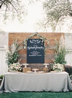 a table topped with cake next to a wooden sign