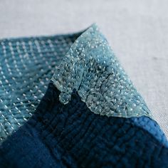 a blue and white piece of cloth on top of a tablecloth with holes in it