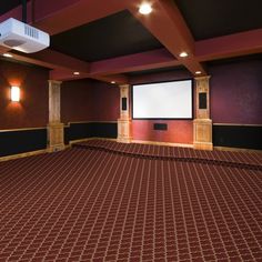 an empty room with a projector screen and red carpet