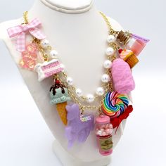 This kawaii statement necklace is called Pink Candy Shop and is a perfect cute charm jewelry gift for any woman in your life including your best friend (or yourself, let's be honest). This piece has been handmade from resin, clay and high quality metal components and features hand painted charms for a quality piece that will be a cute go-to in any charm lovers jewelry collection! Details & Measurements:-Handmade Necklace-High quality glass pearls-Hand-painted charms made from resin & polymer clay-Gumball machine has free floating beads inside! (note it is partially made from glass and fragile)-Choose Gold or Silver Finish -Choose 5, 7 or 9 charms (see list below to find out what charms come on each option)-Charms are chunky and are 1-2" in size (2.5-5cm)-19" (47.5cm) total Necklace Length- Pink Fun Style Charm Necklace, Fun Pink Charm Necklaces, Playful Charms Jewelry For Birthday, Cute Multicolor Charm Necklace, Cute Multicolor Charms Necklace, Cute Multicolor Necklaces With Charms, Cute White Jewelry With Lobster Clasp, Cute Jewelry With Lobster Clasp For Gifts, White Kawaii Jewelry With Cute Design