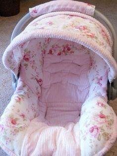 a baby's car seat with pink flowers on it