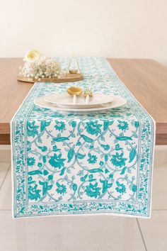 a blue and white table runner on top of a wooden table