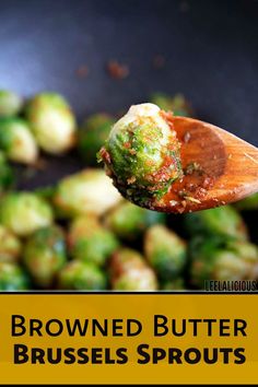 brussel sprouts are being cooked in a pan with a wooden spoon