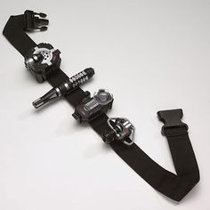 three different types of camera straps on a white surface with one strap holding two cameras