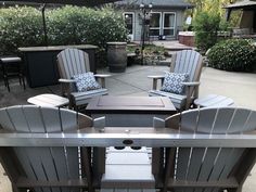 an outdoor table with chairs and umbrella in the background