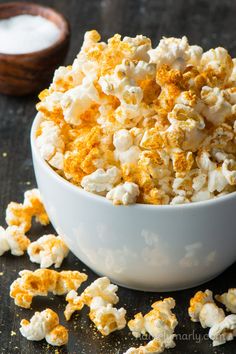 a white bowl filled with popcorn on top of a table