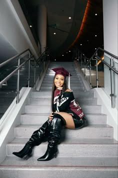 a woman sitting on the steps wearing boots and a graduation cap with her legs crossed