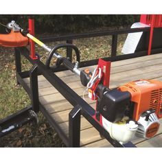 an orange and black machine sitting on top of a wooden deck