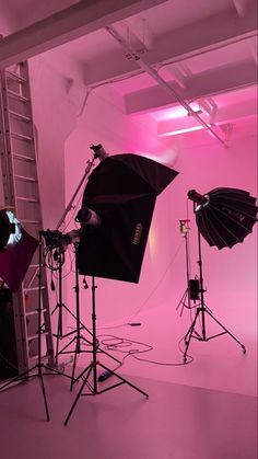 three umbrellas are set up in a pink room