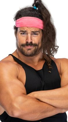 a man with long hair wearing a pink headband and black shirt is posing for the camera