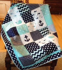 a blue and white quilted chair with an anchor on the front, black and white polka dots