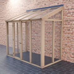 a small wooden structure in front of a brick wall with a glass door on the side