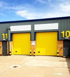 two yellow garage doors in front of a building