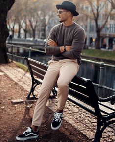 a man sitting on a park bench with his arms crossed