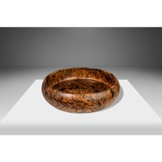 a wooden bowl sitting on top of a white table