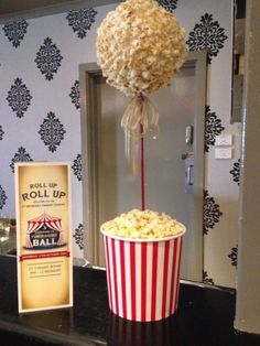 a popcorn bucket filled with popcorn next to a roll up sign