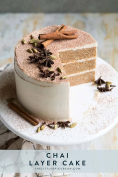 a piece of cake sitting on top of a plate next to cinnamon sticks and spices