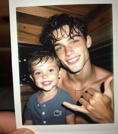 there is a man and a young boy posing for a picture together with one hand in the air