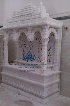 an elaborately carved white shrine in the middle of a room