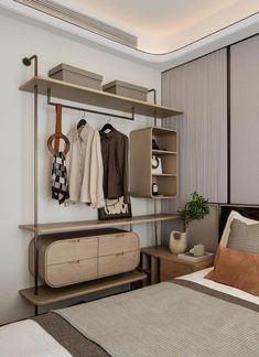 a bed room with a neatly made bed and some clothes hanging on a rack above it