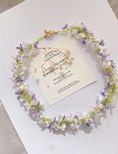 a necklace with flowers and pearls on it sitting on top of a piece of paper