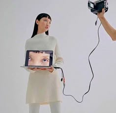 a woman holding a camera and an image of a person's face on the screen