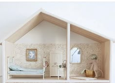 a doll house with a bed, dresser and mirror on the wall next to it