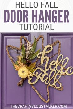 a purple door with the words hello fall on it and a yellow flower in front of it